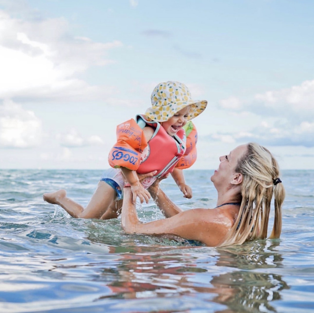 Gemma in the sea lifting her young child