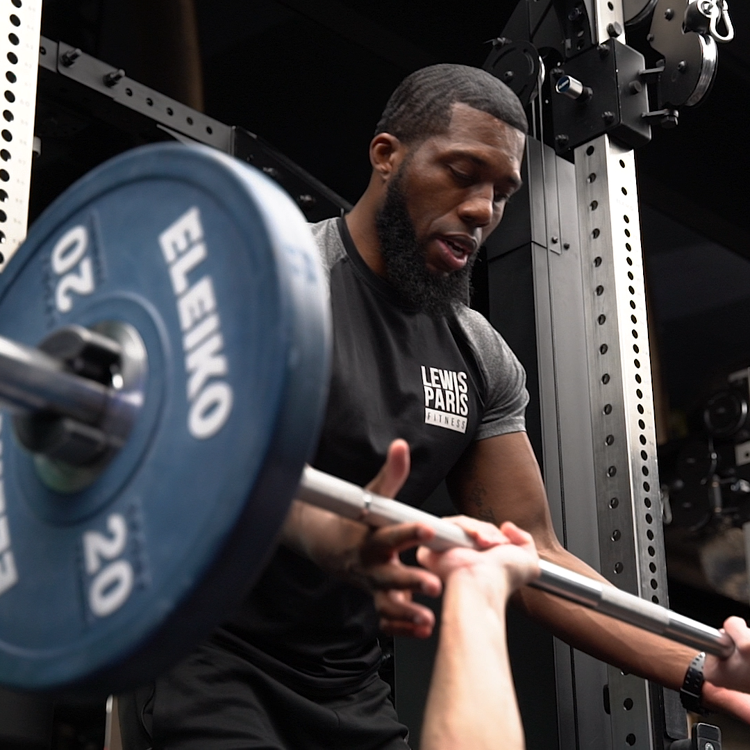 Lewis Paris coaching a client through barbell strength training in London